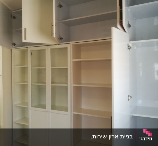 ארונות לבנים עם דלתות פתוחות ומדפים פנימיים